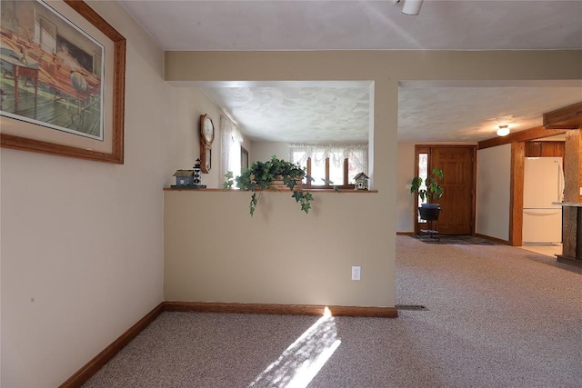 carpeted empty room featuring beamed ceiling