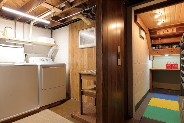 laundry area with wood walls and independent washer and dryer