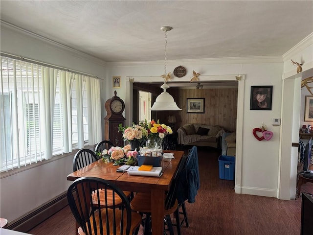 dining space with a baseboard heating unit, ornamental molding, and dark hardwood / wood-style floors