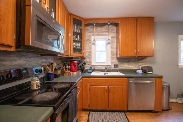 104 Hillcrest Dr, Edinboro, PA 16412 - kitchen with stainless steel appliances, a sink, tasteful backsplash, glass insert cabinets, and light wood finished floors