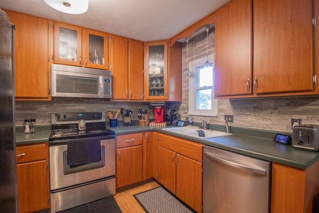 104 Hillcrest Dr, Edinboro, PA 16412 - kitchen with appliances with stainless steel finishes, a sink, tasteful backsplash, light wood-style floors, and glass insert cabinets