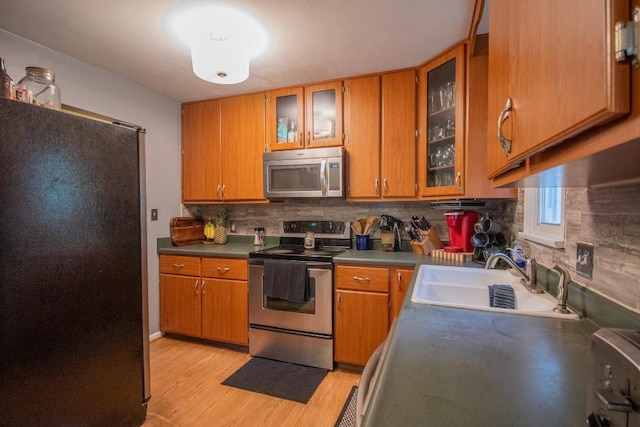 104 Hillcrest Dr, Edinboro, PA 16412 - kitchen with stainless steel appliances, a sink, light wood-style floors, and brown cabinetry