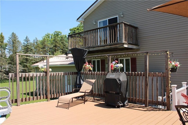 wooden terrace with a lawn and a grill