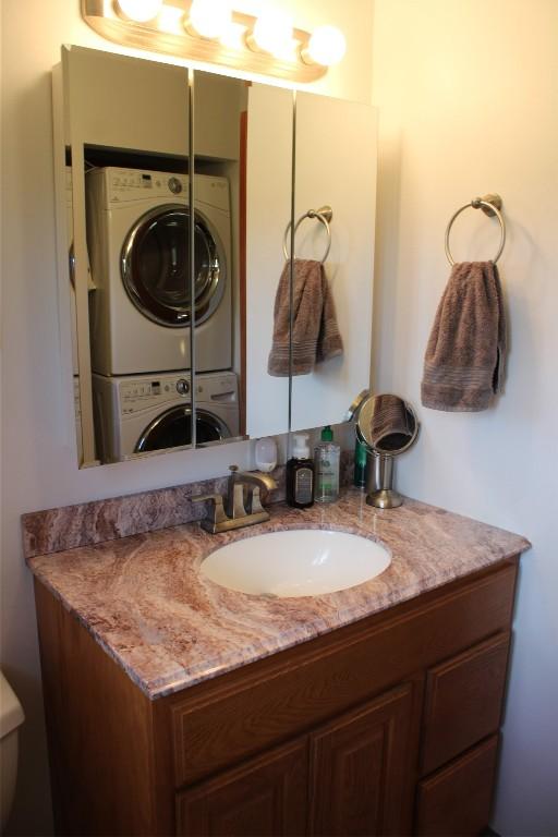 bathroom with vanity and stacked washer / drying machine