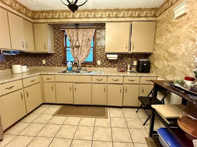 kitchen featuring light tile patterned flooring, tasteful backsplash, sink, and cream cabinets