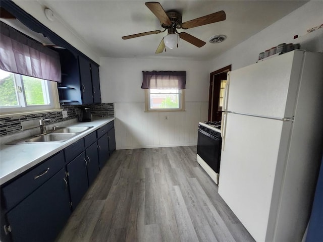 3829 Parade Blvd, Erie, PA 16504 - kitchen with white appliances, a sink, light countertops, wainscoting, and light wood-style floors