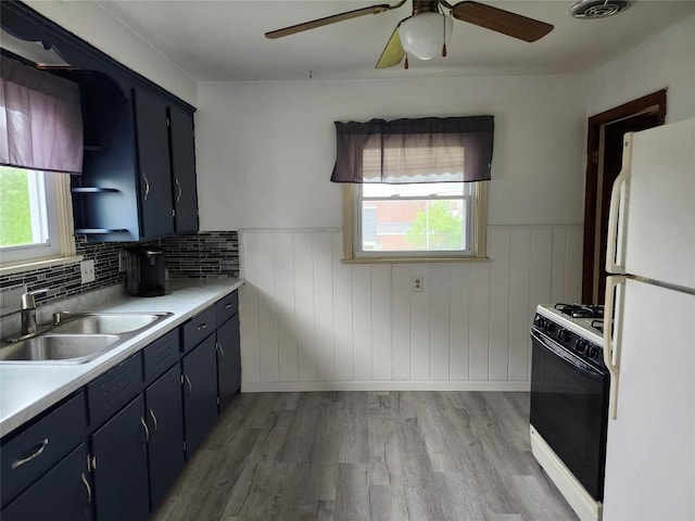 3829 Parade Blvd, Erie, PA 16504 - kitchen featuring freestanding refrigerator, gas range oven, a sink, a wainscoted wall, and blue cabinetry