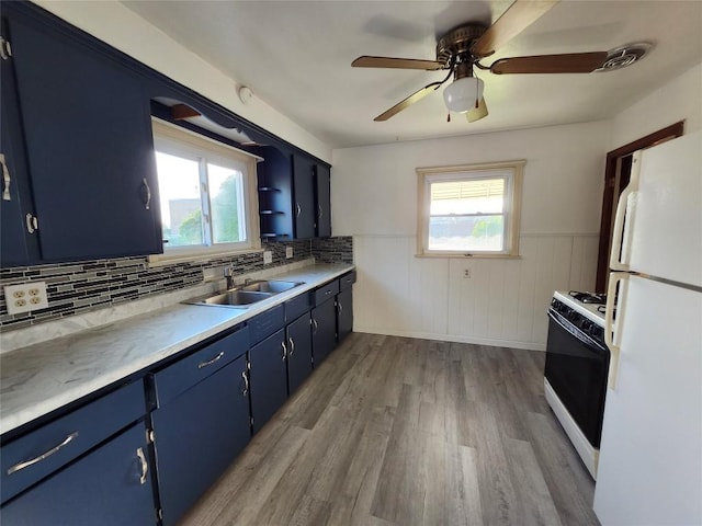 3829 Parade Blvd, Erie, PA 16504 - kitchen with white appliances, blue cabinetry, plenty of natural light, wood finished floors, and wainscoting
