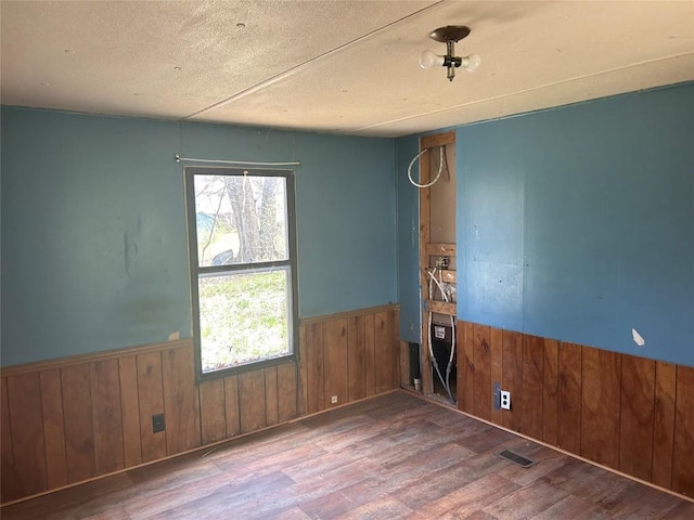 0 Hickory Dr, Espyville, PA 16424 - spare room with wainscoting, wood walls, wood finished floors, and visible vents