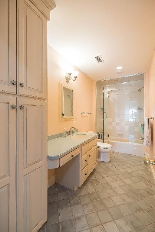 bathroom with shower / tub combination, toilet, vanity, visible vents, and tile patterned floors