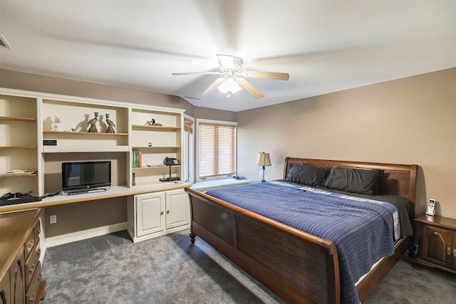 bedroom with a ceiling fan, built in study area, dark carpet, and baseboards