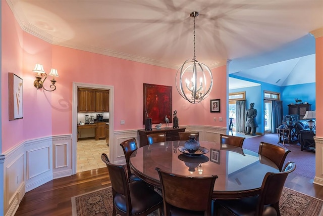 dining room with a wainscoted wall, crown molding, wood finished floors, and a notable chandelier