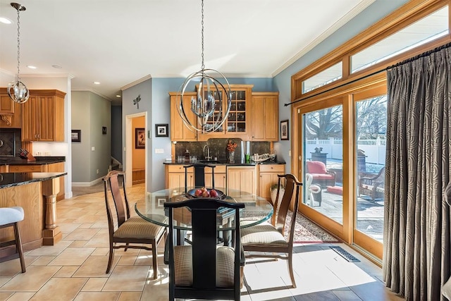 dining area with ornamental molding, french doors, baseboards, and an inviting chandelier