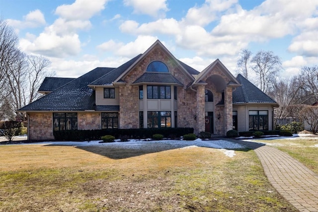 view of front facade with stone siding and a front yard