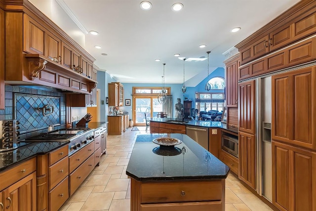 kitchen with a kitchen island, brown cabinets, built in appliances, a peninsula, and a sink