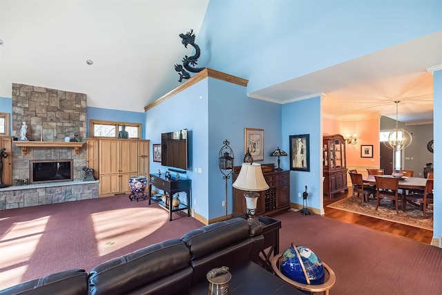 carpeted living area featuring crown molding, a notable chandelier, a fireplace, and baseboards