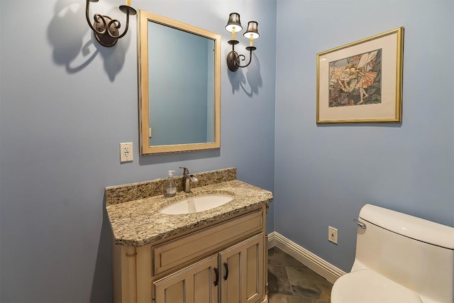 half bath with toilet, vanity, and baseboards