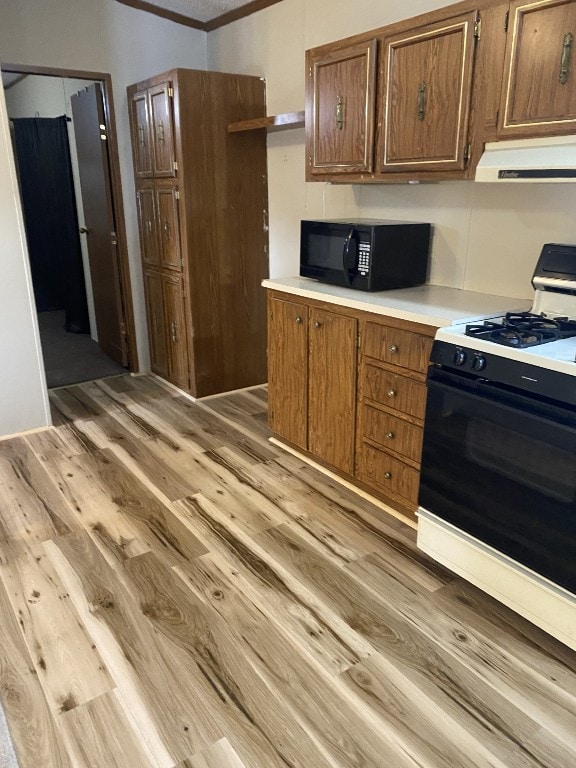 kitchen featuring light hardwood / wood-style floors, ornamental molding, and range with gas stovetop