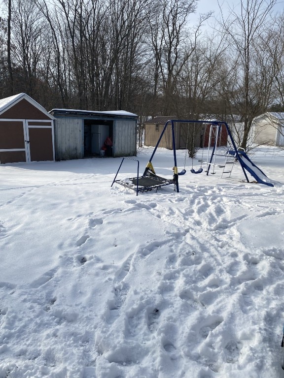 yard layered in snow with a storage shed