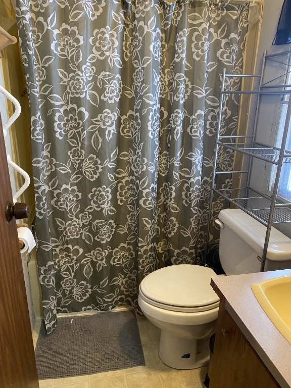 bathroom featuring toilet, vanity, and tile patterned flooring