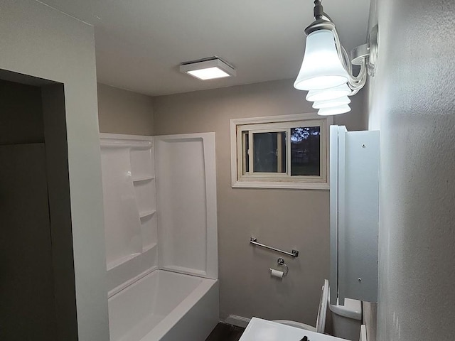 bathroom featuring tub / shower combination and toilet