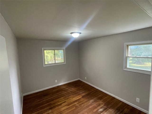 empty room with dark hardwood / wood-style flooring