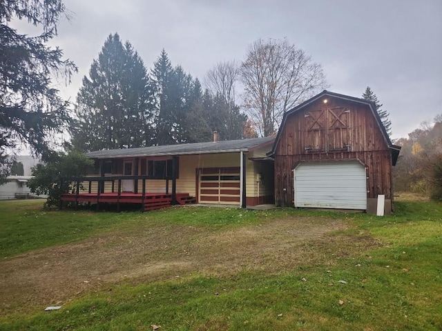 view of front of home featuring a deck, an outdoor structure, and a front lawn