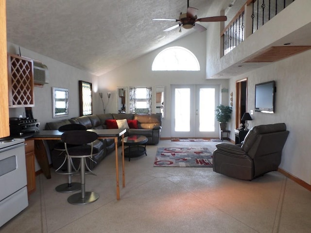 living room featuring ceiling fan, high vaulted ceiling, a wall mounted AC, a textured ceiling, and french doors