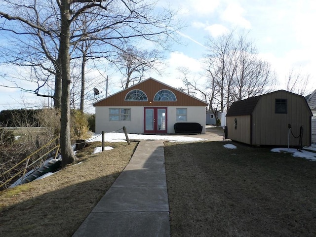 view of front of house featuring french doors and a storage unit