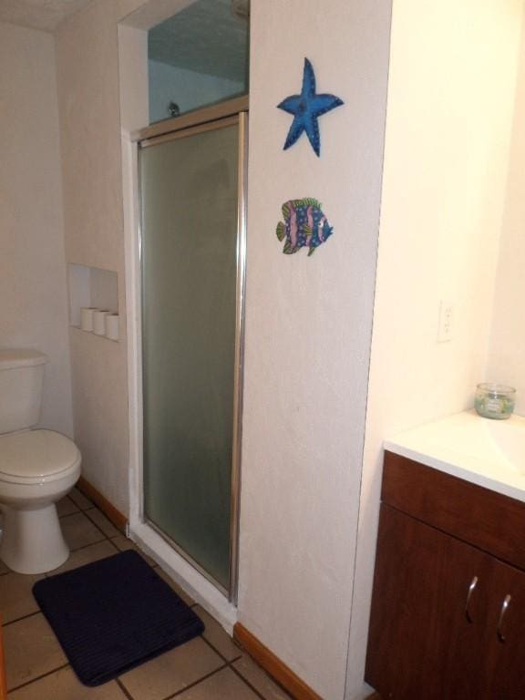 bathroom with walk in shower, tile patterned floors, toilet, and vanity