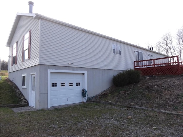 view of side of property featuring a garage and a wooden deck