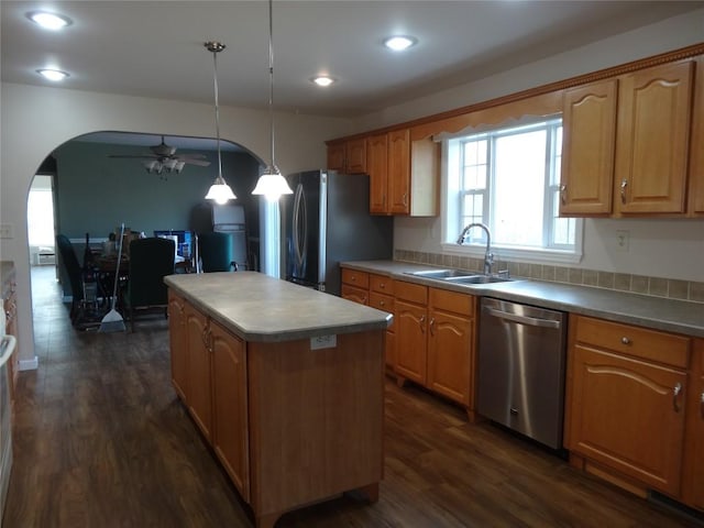 kitchen featuring a center island, sink, ceiling fan, decorative light fixtures, and stainless steel appliances