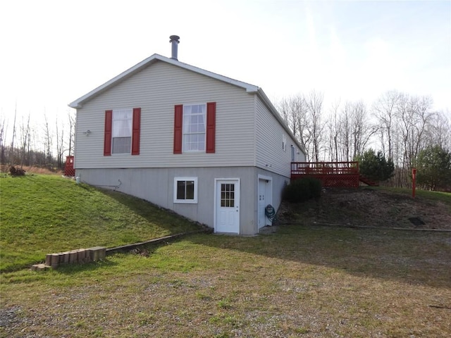 view of side of home featuring a deck and a lawn