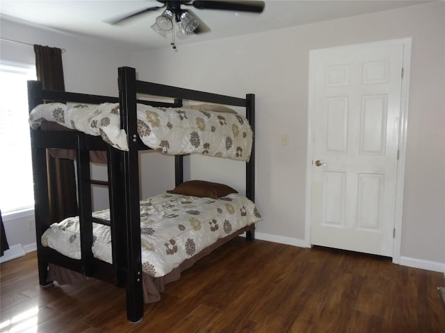 bedroom with multiple windows, ceiling fan, and dark wood-type flooring