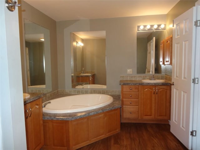 bathroom featuring hardwood / wood-style floors, a bathtub, and vanity