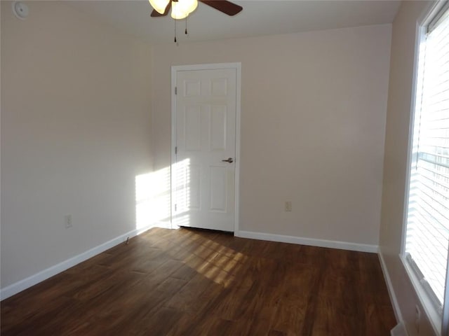 empty room with ceiling fan and dark wood-type flooring