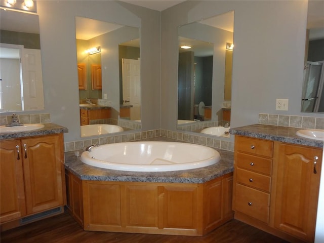 bathroom featuring hardwood / wood-style floors, vanity, and a tub to relax in