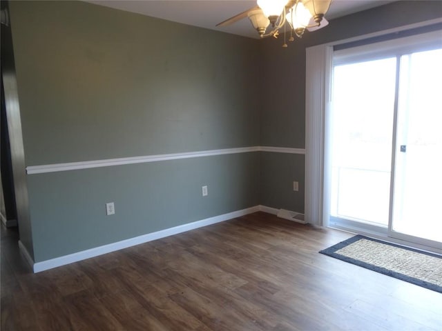 unfurnished room featuring dark hardwood / wood-style flooring and a chandelier