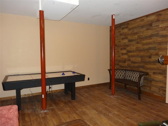 game room featuring dark hardwood / wood-style floors and wood walls