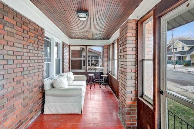 sunroom featuring a healthy amount of sunlight and wood ceiling