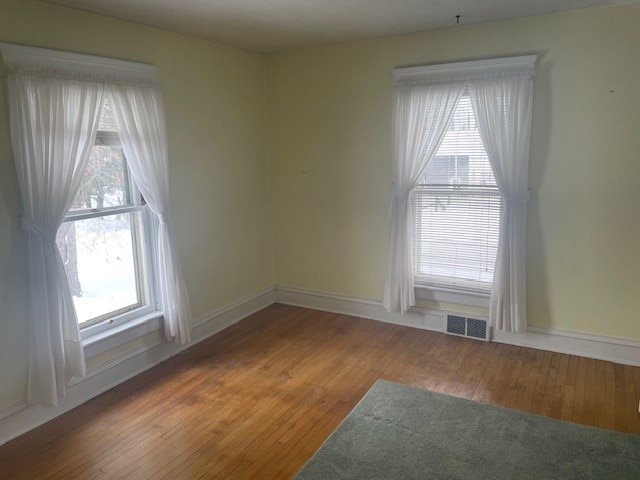 unfurnished room with hardwood / wood-style floors