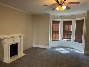 unfurnished living room featuring crown molding, ceiling fan, and dark carpet