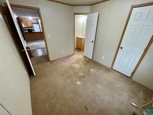 unfurnished bedroom with crown molding and light carpet