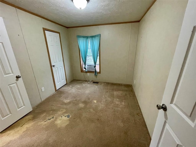 carpeted spare room with cooling unit, a textured ceiling, and ornamental molding