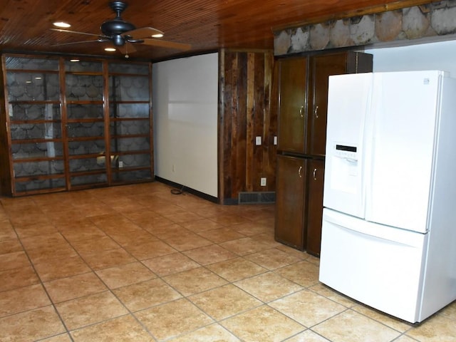 kitchen with ceiling fan, wood walls, white fridge with ice dispenser, and wooden ceiling