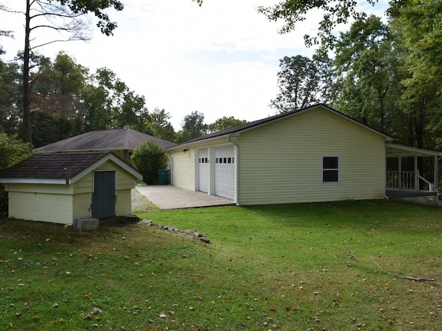 back of house featuring an outbuilding and a yard