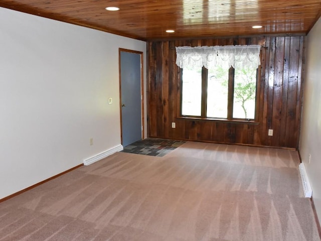 empty room with carpet, wood walls, and wood ceiling