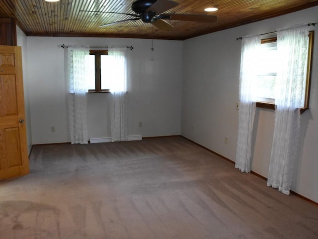 carpeted empty room featuring ceiling fan, a healthy amount of sunlight, and wood ceiling