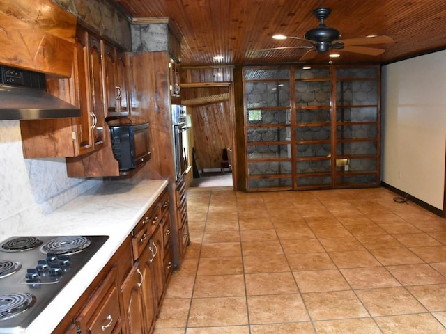 kitchen with wooden ceiling, electric cooktop, ceiling fan, wall chimney exhaust hood, and light tile patterned flooring