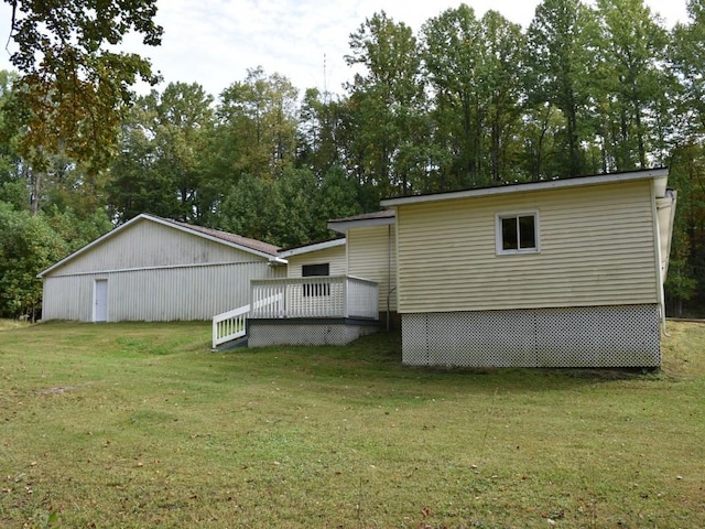 back of house featuring a lawn and a wooden deck